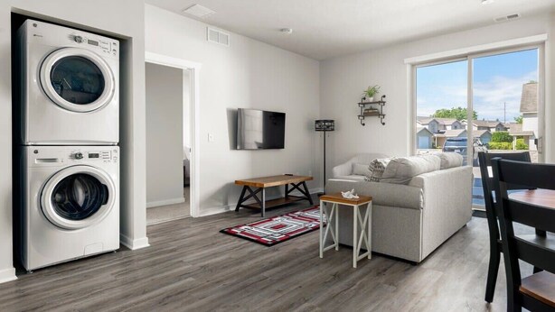 Eine moderne Wohnung mit Waschmaschine, Flachbildfernseher, Sofa und Essbereich.