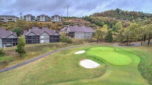 A golf course with bunkers and a road leading to the clubhouse. - Gorgeous Golf Views, Quiet/Large, Resort and Pools (Reeds Spring)