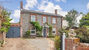 A stone house with a paved driveway and a small garden. - 4 bedroom accommodation in Bacton, Norwich (Bacton, Norwich)