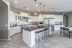 Enjoy cooking in this well-equipped kitchen with a large island, stainless steel appliances, and ample storage.
