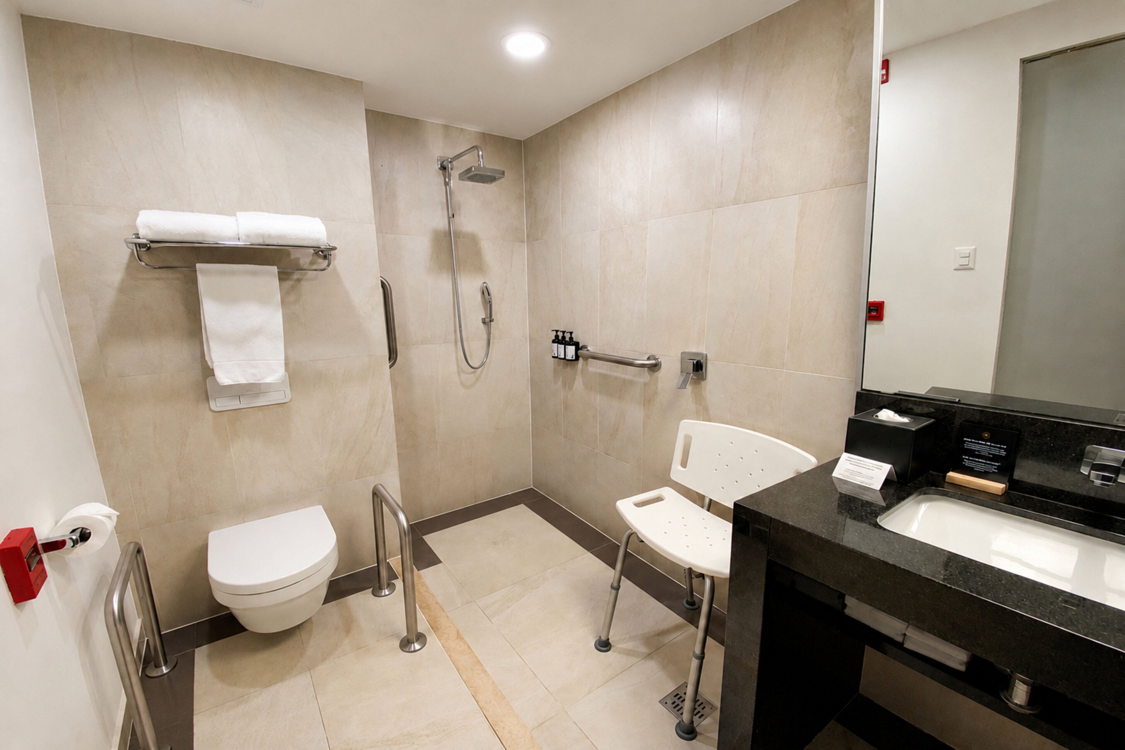 A modern bathroom with a toilet, shower, and sink.