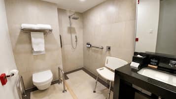 A modern bathroom with a toilet, shower, and sink.