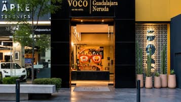 The entrance to VOCO An IHG Hotel Guadalajara Neruda with a modern facade and a glass entrance.
