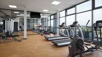 A gym with treadmills, elliptical machines, and weight equipment.