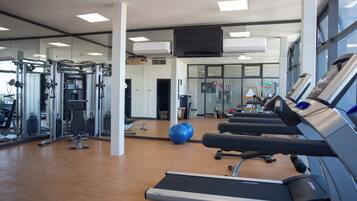 A gym with treadmills, weight machines, and exercise balls.