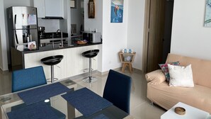 A modern apartment with a kitchen, dining area, and living room. - Beautiful condo with views of the beach (Cartagena)