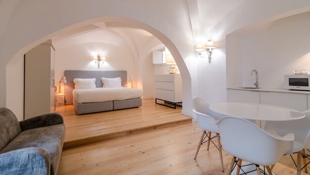 A modern bedroom with a bed, bedside lamps, a desk, and a chair. - Casa Morgado Esporão (Évora)
