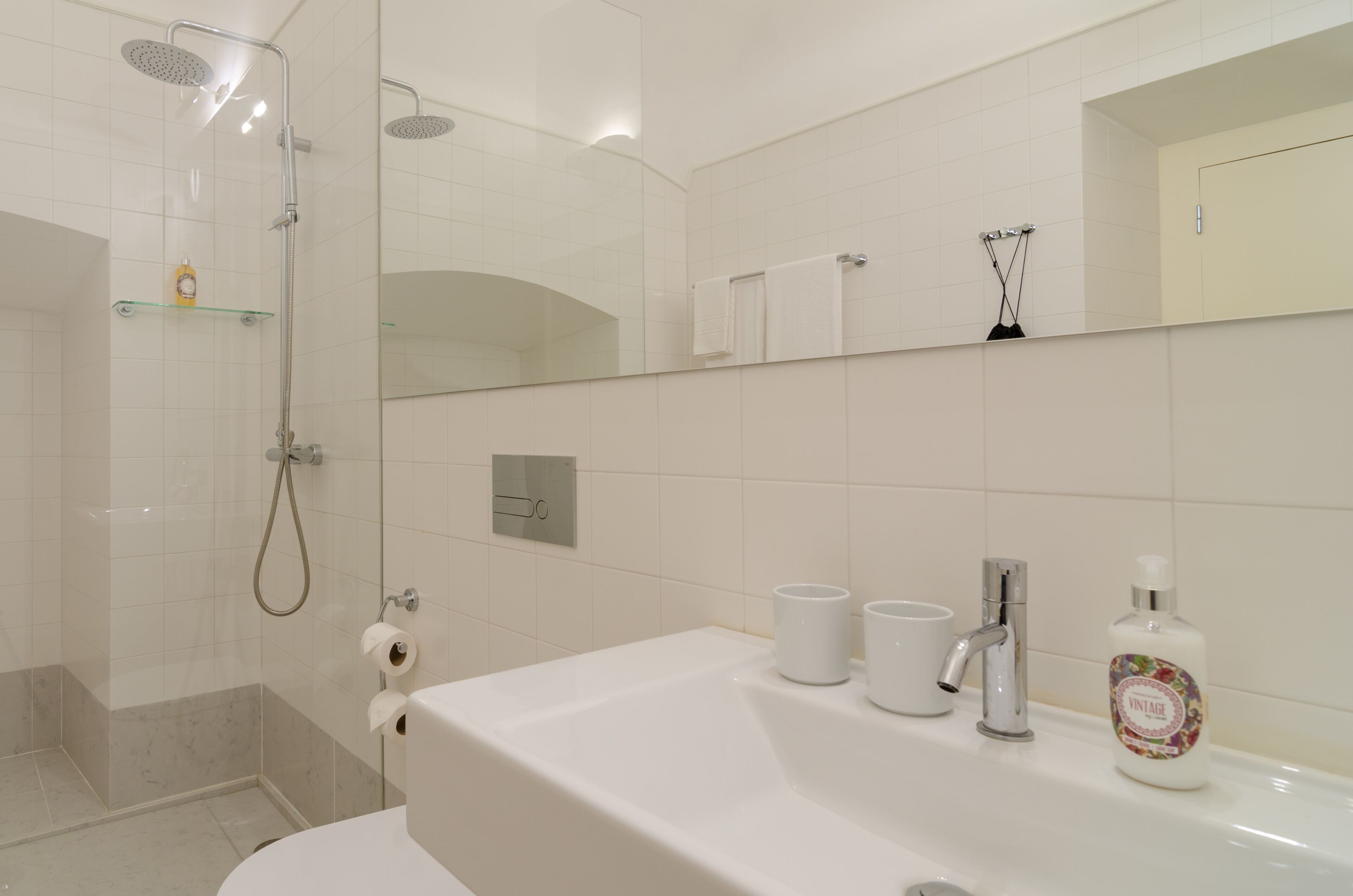 Un baño moderno con ducha, inodoro y lavamanos.