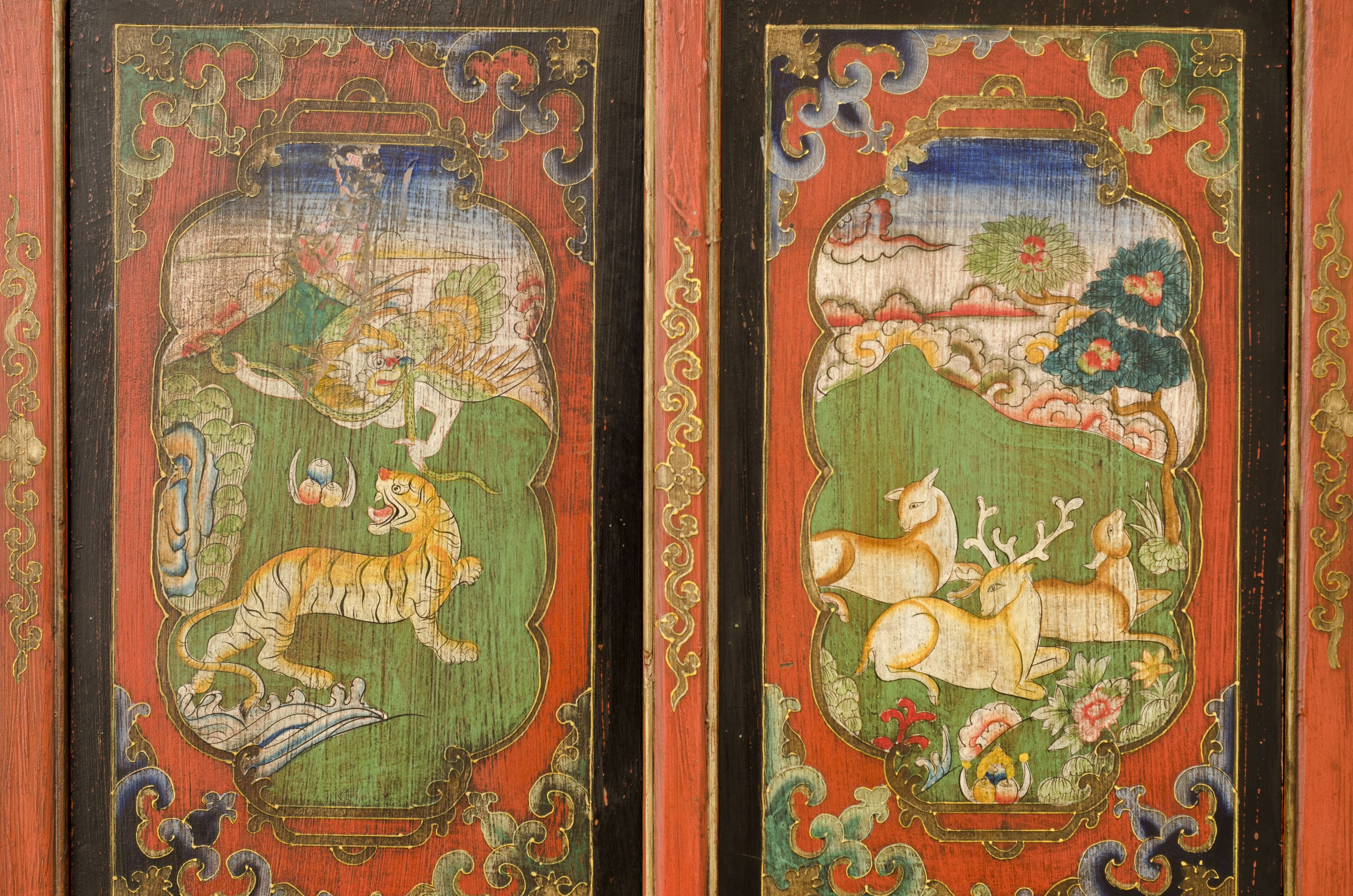 Una obra de arte japonesa tradicional que muestra un tigre y un ciervo, enmarcada por adornados bordes rojos y dorados.