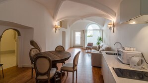 A spacious kitchen with a dining area, featuring a wooden table, chairs, a microwave, and a coffee maker. - Casa Morgado Esporão (Évora)