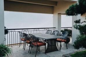An outdoor patio with a table and chairs, surrounded by a metal railing and potted plants. - Pistachio Hotel Sapa (Sa Pa)
