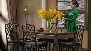 A dining area with a table, chairs, a vase with yellow flowers, and a lamp. - Pistachio Hotel Sapa (Sa Pa)