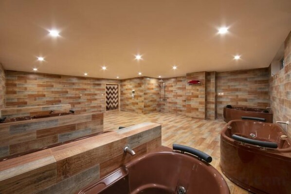 A spa area with a wooden reception desk, multiple seating areas, and a shower with a tiled wall. - Pistachio Hotel Sapa (Sa Pa)