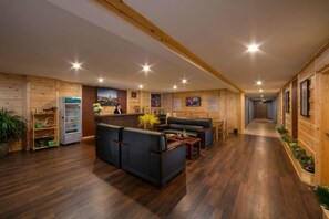 Un hall de hotel con paredes de madera, una recepción, zona de estar y un pasillo.