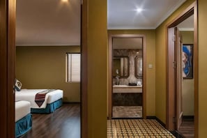 Une chambre d’hôtel avec un lit, une salle de bain avec un miroir et un sol à motifs.