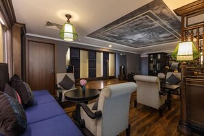 A modern living room with a sofa, armchairs, a coffee table, and a fireplace. - Pistachio Hotel Sapa (Sa Pa)