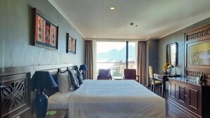 A hotel room with a large bed, a desk with a chair, and a view of the outdoors. - Pistachio Hotel Sapa (Sa Pa)