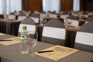 A conference table with a bottle and glass, name tags, and a menu. - Pistachio Hotel Sapa (Sa Pa)