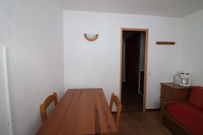 Cozy space with a dining table and chairs, a sofa, and a cabinet with a coffee maker.