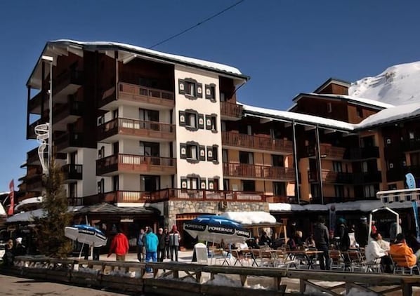 Experience the charm of a traditional alpine hotel with balconies on each floor, perfect for taking in the surrounding mountain views.