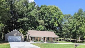 A single-story house with a garage, a front porch, and a well-maintained lawn. - Lake Life Getaway! (Winchester)
