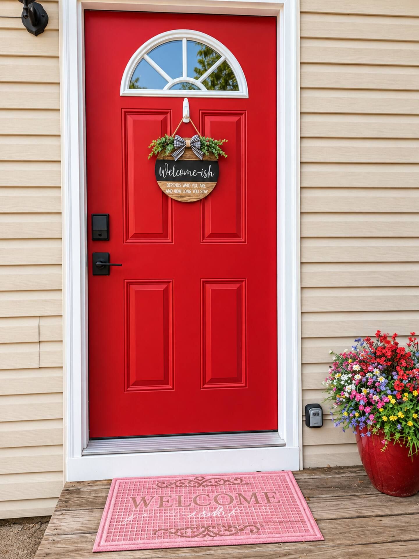 A red door with a welcome sign, a window, and a doormat.