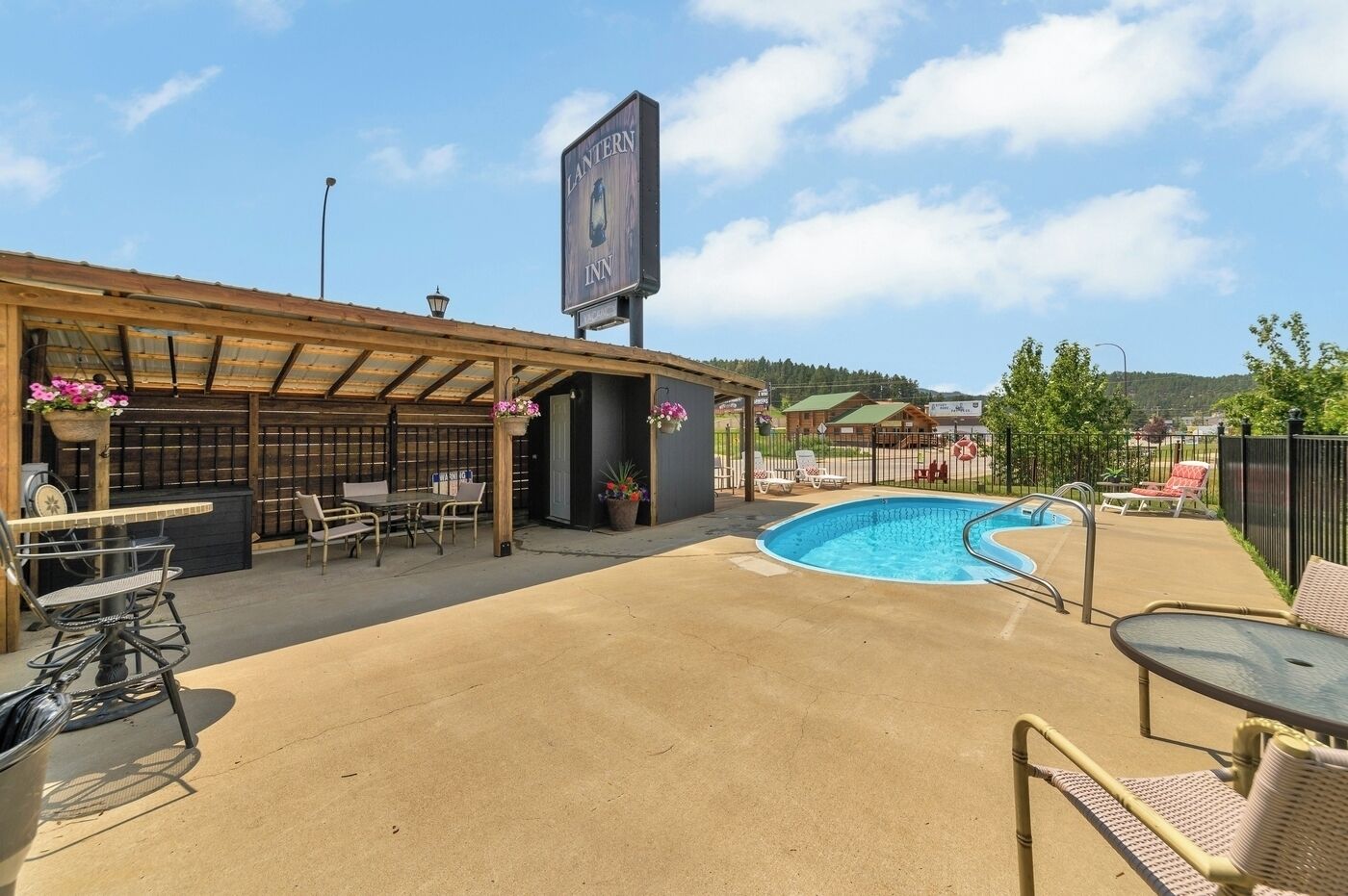 Un espace extérieur avec une piscine, des chaises longues et un coin salon abrité.