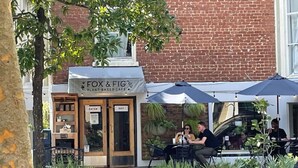 Ein Café namens 'Fox & Fig' mit Außenbereich und Sonnenschirmen.