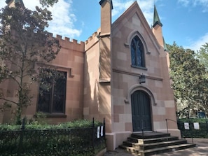 Uma igreja com uma janela em arco ogival, uma porta escura e um pequeno conjunto de degraus que levam à entrada.