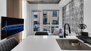 Una cocina moderna con una isla central, horno empotrado y pileta de acero inoxidable.