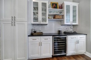 A kitchen with white cabinets, a black countertop, and a built-in oven.