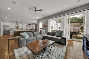 A modern living room with a sectional sofa, a wooden coffee table, and a patterned rug.