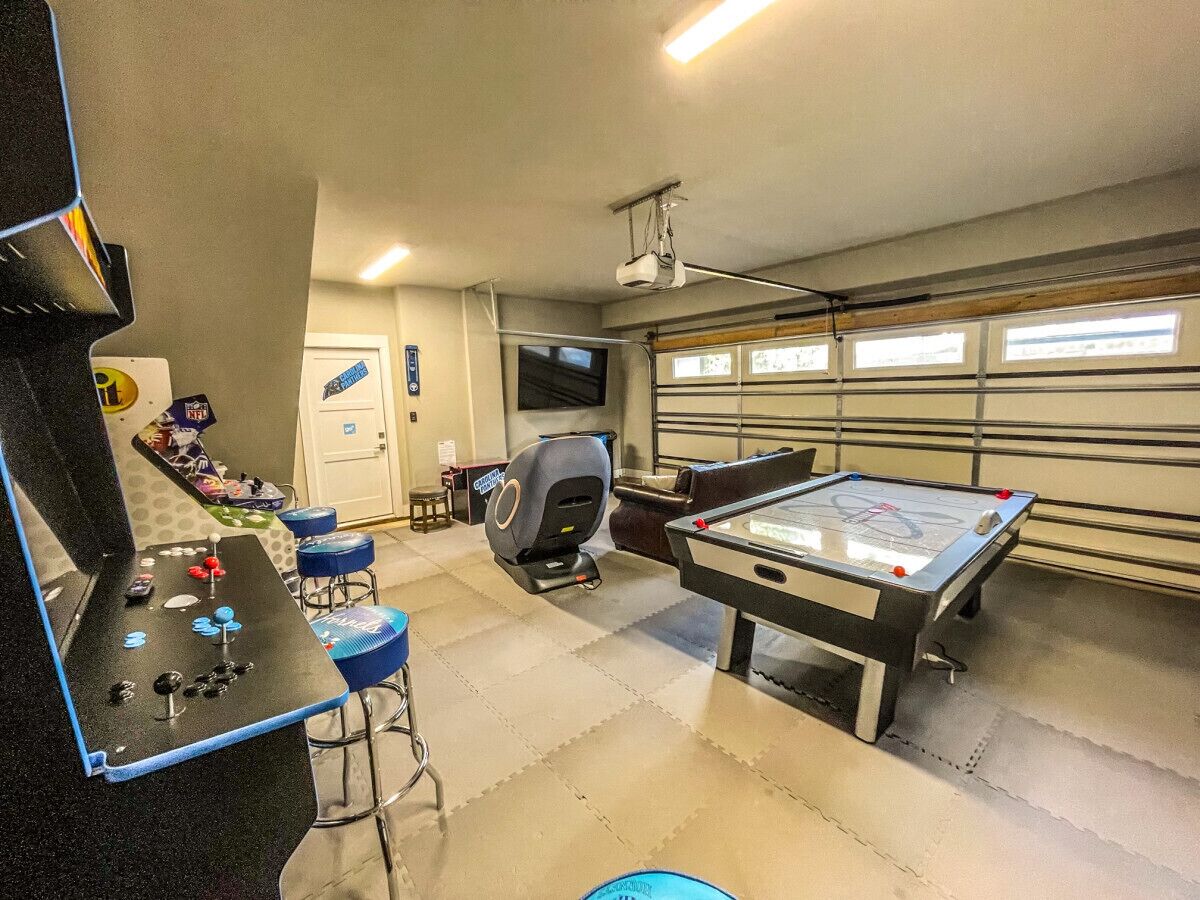 A recreational room with a pool table, a foosball table, and a gaming area.
