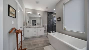 Une salle de bain moderne avec une grande baignoire, un banc en bois et une douche à l’italienne.