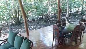 A wooden deck with wicker furniture and a table.