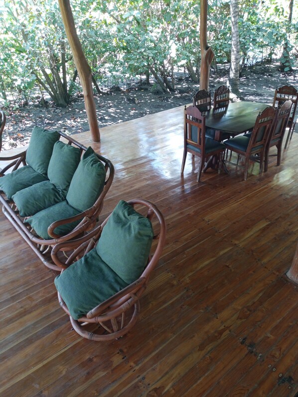 A wooden deck with wicker furniture and a table.