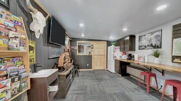A compact kitchen with a wooden countertop, a refrigerator, and a microwave.