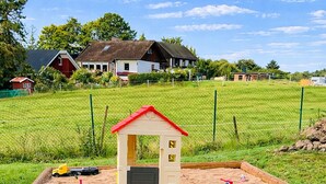 A sandbox with toys and a small playhouse. - Extertal-Ferienpark - PREMIUM HOLIDAY HOUSE - Sauna, fireplace, hiking, relaxation #49 (Extertal)