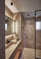 Suite estudio Deluxe | Baño | Ducha, artículos de higiene personal gratuitos y secador de pelo