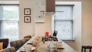 A modern kitchen with a marble countertop, a gas stove, and a coffee station set up for a meeting. - 2 bedroom accommodation in Falkland (Falkland)
