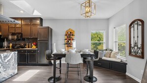 A modern kitchen with dark wood cabinets, a marble countertop, and a built-in wine rack. - Newly Redesigned Lakefront Condo with Dock near Downtown Fun! (Hot Springs)