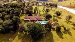 A large house with a swimming pool, surrounded by lush greenery and a river. - Sítio King - Bragança Paulista (Piracaia)
