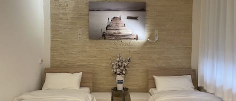 Eenvoudige kamer, 2 eenpersoonsbedden, gedeelde badkamer | 1 slaapkamer, een bureau, gratis wifi, beddengoed
