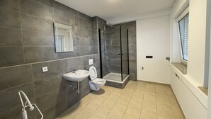 A modern bathroom with a sink, toilet, and walk-in shower. - Erft Apartment (Kerpen)