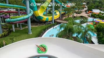 A water park with multiple slides and pools, surrounded by greenery.