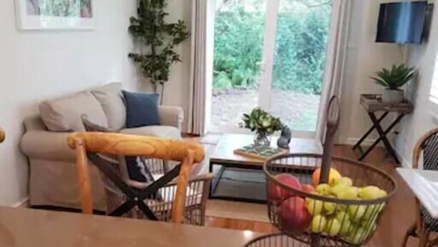 A dining area with a table, chairs, and a fruit basket. - Stylish Sale Street Studio - Walk to Town (Orange)