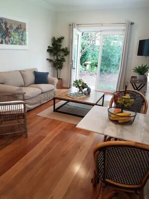 Ein Wohnzimmer mit einer Couch, einem Couchtisch und einem Essbereich mit Stühlen.