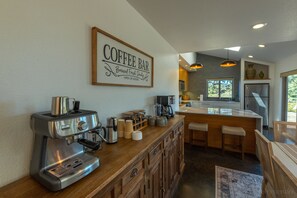 Una cocina con barra para café, máquina de espresso y diferentes utensilios para prepararlo.