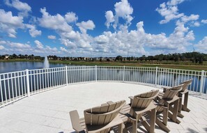 Relax in a serene outdoor seating area overlooking the water, surrounded by a semi-circle of Adirondack chairs.
