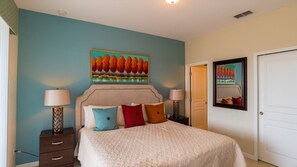 A bedroom with a bed, two bedside tables, a nightstand, a door, and a wall with a painting. - New Listing! Windsor Hills Resort, 3mi to Disney & 12mi to Universal - GRH438892 (Kissimmee)